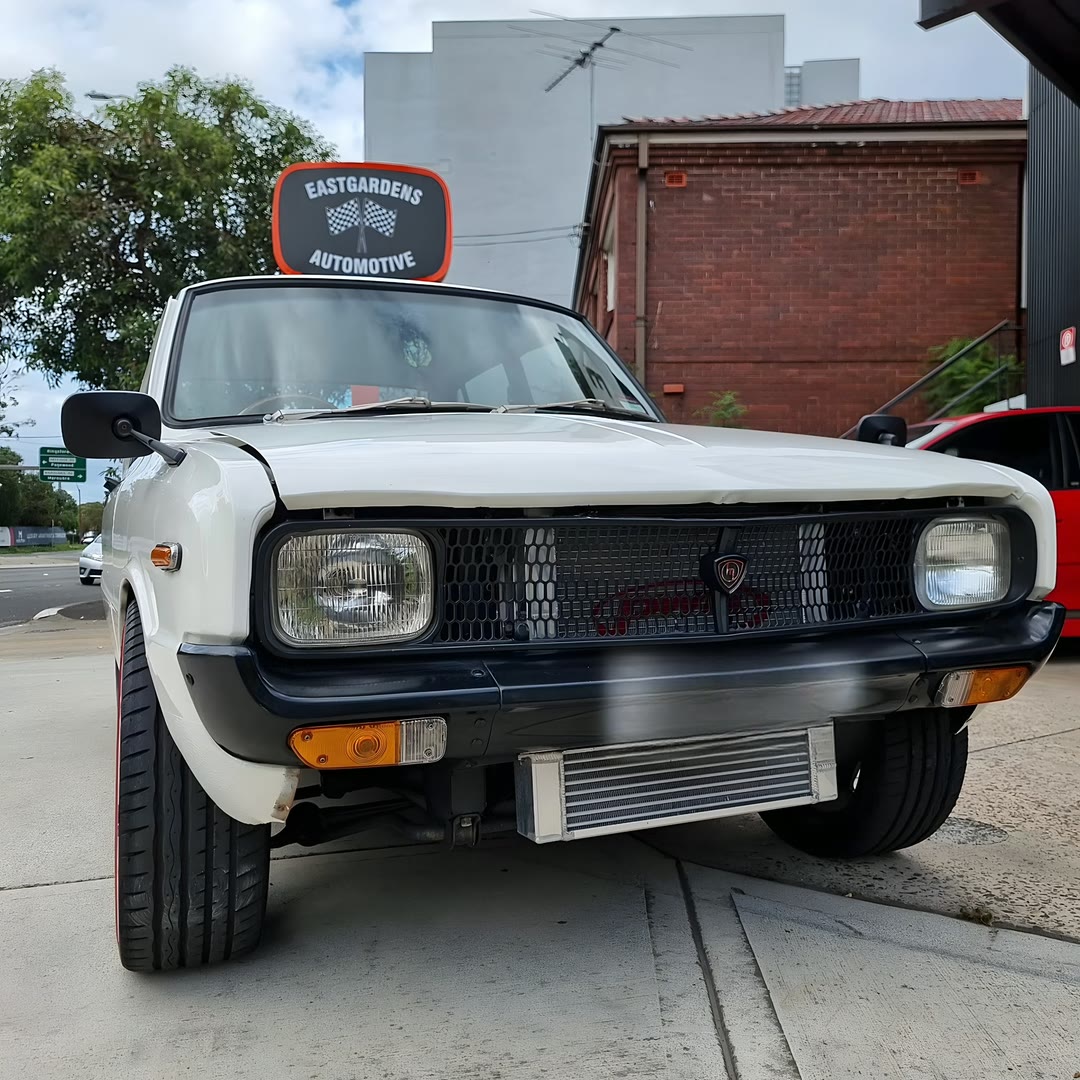 A classic car parked under the Eastgardens Automotive sign